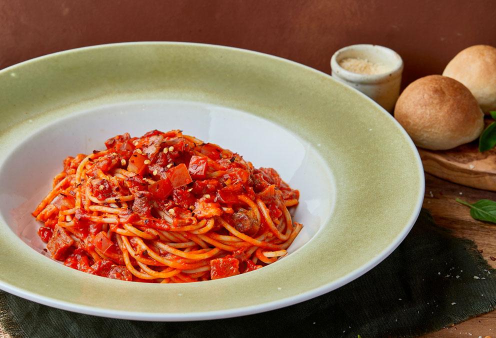 pasta amatriciana con salsa napolitana, aji, tocineta y tomate il forno